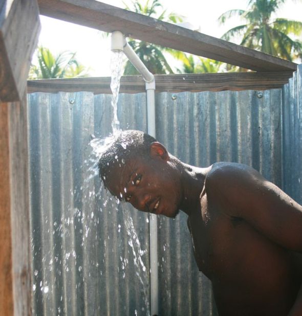 A young man bathes at a public shower in Petit Goâve, Haïti