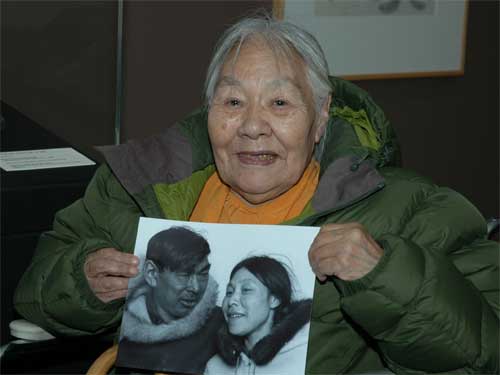Kenojuak in 2009, holding a 1968 photograph of herself with husband Johnniebo Ashevak