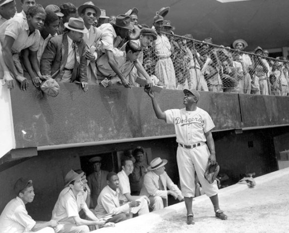 Jackie Robinson durante el entrenamiento-primavera de marzo 1948_Ciudad Trujillo, La República Dominicana_Jackie Robinson, first baseman of the Brooklyn Dodgers, returns an autograph book to a fan during the Dodgers' spring training in Ciudad Trujillo, now Santo Domingo, in the Dominican Republic on March 6th, 1948