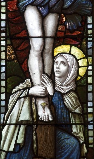 Mary Magdalen at the foot of The Cross as Jesus suffered_an 1886  stained glass window from Saint Bledrws Church in Wales