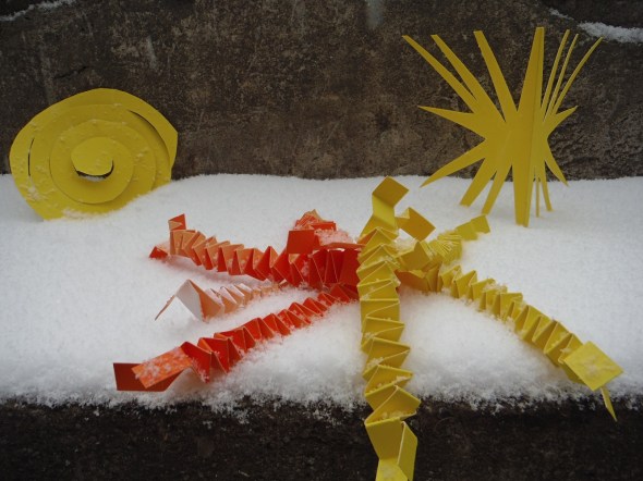 Paper cutouts yellow and orange on stone steps in the snow_Toronto Canada