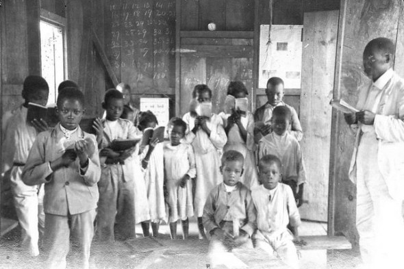 Jamaican primary schoolhouse with children and their teacher_early 20th century photograph