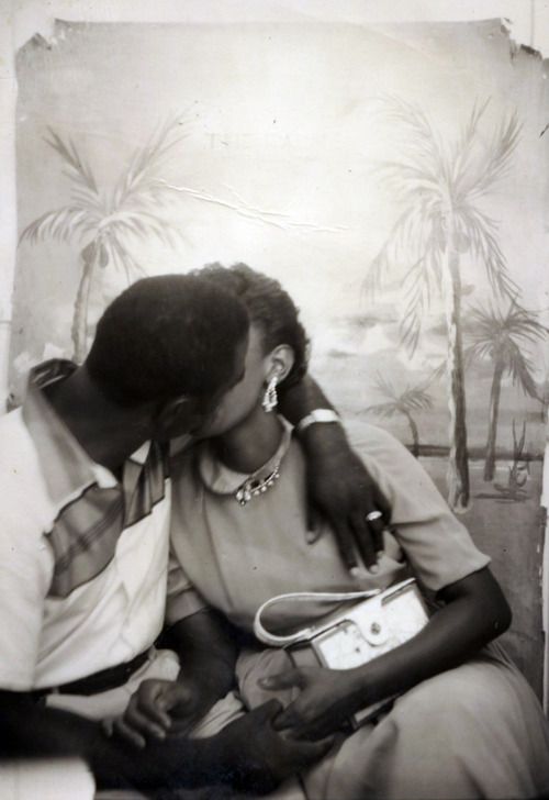 Vintage photograph for Valentines Day_African American couple kissing during a photography studio portrait taking