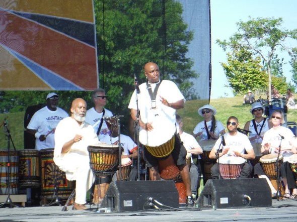 Muhtadi Thomas, seated at front left, performs with his World Drummers ensemble at Woodbine Park in Toronto_June 4th, 2016